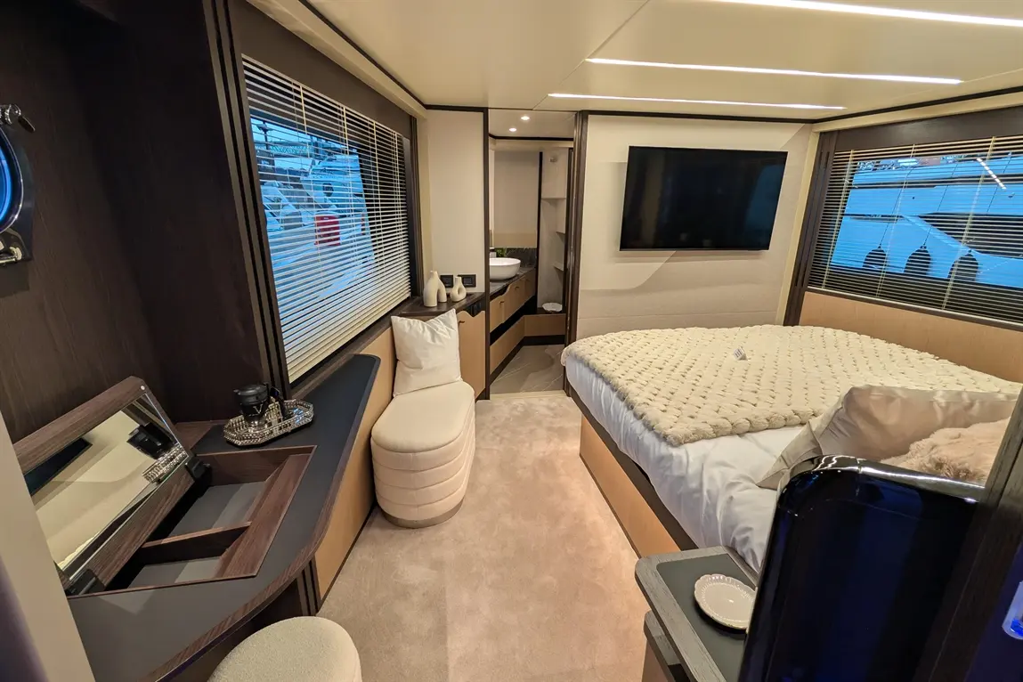Luxurious cabin featuring a plush bed, modern furniture, a TV, and a well-lit area with a view through large windows.